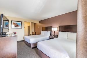 a hotel room with two beds and a sink at Grand Legacy At The Park in Anaheim