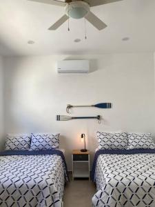 a bedroom with two beds and a ceiling fan at CASA PITAHAYA con alberca privada Col El Mirador in San Carlos +12 photos