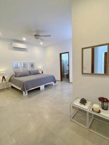 a white bedroom with a bed and a table at CASA PITAHAYA con alberca privada Col El Mirador in San Carlos