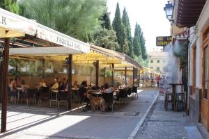 Central, near the Alhambra, quiet and autentic! في غرناطة: مجموعة من الناس يجلسون على الطاولات في مطعم خارجي