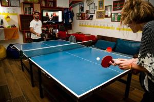 a woman playing a game of table tennis at Books Hostel in Rio de Janeiro