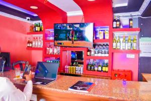una persona que toma una foto de un bar con ordenador portátil en Consular Resort Meru, en Meru