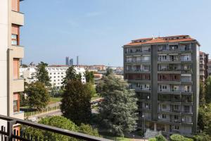 a tall apartment building with trees and buildings at Moderno, luminoso, spazioso con VISTA in Milan