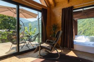 a room with a balcony with a bed and an umbrella at Woodpecker Georgia in Batumi