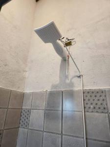 eine Dusche im Bad mit einem an der Wand befestigten Schlauch in der Unterkunft Bangalô com Vista Parcial para o Mar in São Sebastião