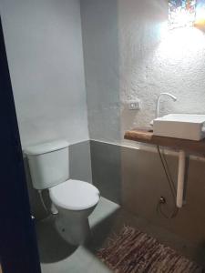 ein Badezimmer mit einem weißen WC und einem Waschbecken in der Unterkunft Bangalô com Vista Parcial para o Mar in São Sebastião