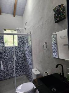 ein Bad mit einer Dusche, einem WC und einem Waschbecken in der Unterkunft Bangalô com Vista Parcial para o Mar in São Sebastião