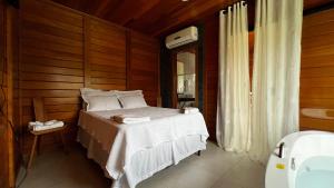 una camera da letto con letto in una camera in legno di Sítio Chalé dos Ipês a Santana do Paraíso