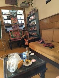 a woman sitting in a living room with a couch at The Elite Castle in Jaisalmer