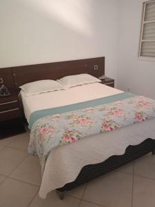 a bedroom with a bed with flowers on it at Conexão Hostel in Alto Paraíso de Goiás