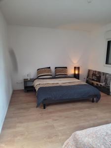a bedroom with a bed and a wooden floor at chambres chez l habitant villa de luxe in Mouvaux