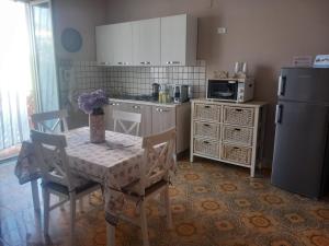 uma cozinha com uma mesa com cadeiras e um frigorífico em Stella Marina Bed and Breakfast sul mare em Realmonte