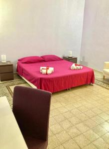 una camera da letto con un letto rosa con due regali sopra di Oasi Palermitana a Palermo