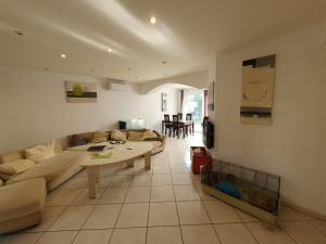 ein Wohnzimmer mit einem Sofa und einem Tisch in der Unterkunft Maison quartier résidentiel in Saint-Priest