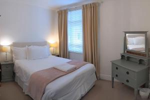 a bedroom with a bed with a mirror and a window at Quirky Coach House in Plymouth +15 photos