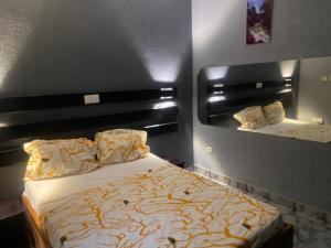 a bedroom with a large bed and a mirror at Sunrise Center Bonapriso 104 in Douala
