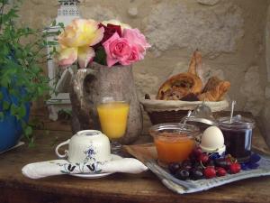 una mesa con un jarrón de flores y algunas bebidas en Bastida de Beata, en Noailles