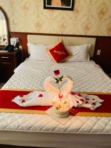 uma cama com um cisne feito de toalhas e velas em Khách Sạn Nam Sơn em Ðông Khê