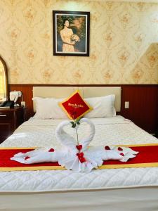 a hotel room with a bed with a white bedspread at Khách Sạn Nam Sơn in Ðông Khê