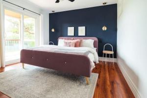 a bedroom with a large bed and a blue wall at Grays Lane - Minutes to Sandbanks in Bloomfield