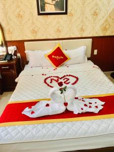 ein Hotelbett mit zwei Herzen aus Handtüchern in der Unterkunft Khách Sạn Nam Sơn in Ðông Khê