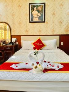 Una cama con dos toallas y una sombrilla. en Khách Sạn Nam Sơn en Ðông Khê