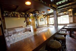 a bar with glasses and a bottle of wine at Hotel Zur Windmühle in Stapelfeld