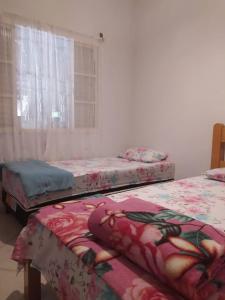 3 Betten in einem Zimmer mit Fenster in der Unterkunft Conexão Hostel in Alto Paraíso de Goiás