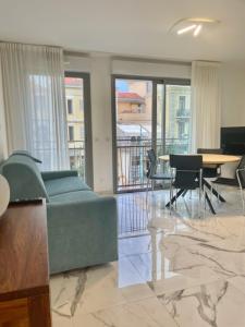 a living room with a couch and a table with chairs at Saint Jhon in Menton