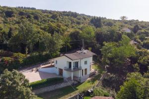 una vista aérea de una casa blanca en un bosque en Garda Lake Panorama Villa with Garden & BBQ, en San Zeno di Montagna