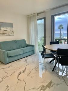 a living room with a blue couch and a table at Saint Jhon in Menton