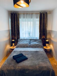 a bedroom with a bed with two lamps and a window at ClickTheFlat Solidarności City Center Apart Rooms in Warsaw