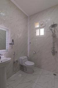 Baño blanco con aseo y lavamanos en جراند فيوتشر en Abha