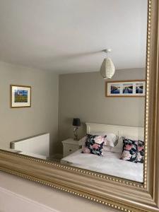 a mirror reflection of a bed in a bedroom at Cosy beach house steps from the sea in Cromer
