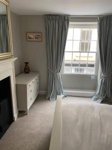 a bedroom with a bed and a window at Cosy beach house steps from the sea in Cromer