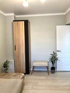a bedroom with a bed and a chair and a door at Apartment in Taraz
