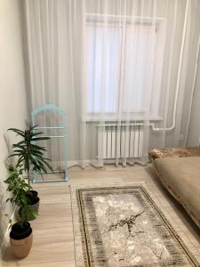 a bedroom with a table and a chair and a rug at Apartment in Taraz