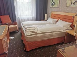 a hotel room with a large bed and a chair at Hotel Alter Hof 