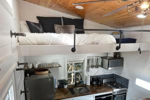 una casetta minuscola con un letto sopra di Cozy Lakeview Cottage a Mills River