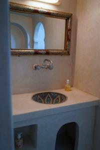 a bathroom with a sink and a mirror at Riad Marhaba Merzane in Merzane