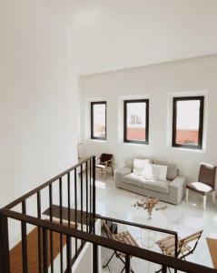 a white living room with a couch and chairs at Antigua Casa Hermandad in Seville