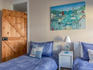 a bedroom with a bed and a wooden door at Seas the Day Cottage, Dartmouth in Dartmouth