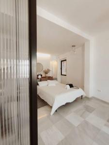 sypialnia z dużym łóżkiem w białym pokoju w obiekcie Antigua Casa Hermandad w Sewilli