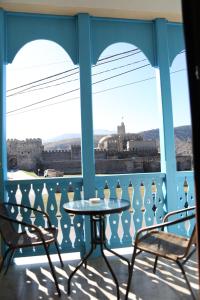 a table and chairs on a balcony with a view of the city at Luxor Rabath in Akhaltsikhe