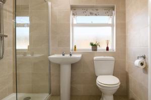 een badkamer met een toilet, een wastafel en een raam bij Hafod Wen near the beach and Llandudno town Centre in Llandudno