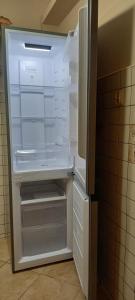 un frigorifero vuoto con la porta aperta in una cucina di Mieszkanie w centrum a Kutno