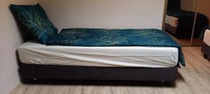Una cama pequeña con una manta azul encima. en Mieszkanie w centrum, en Kutno