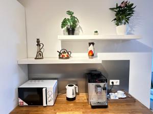 uma cozinha com um micro-ondas e comodidades para preparar café num balcão em Green Paradise & Cozy Retreat Salzburg with free parking em Salzburgo