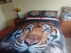 Ein Bett mit einem Tiger-Bild drauf. in der Unterkunft 216 GLYN EIDDEW (IVY VALE) in Cardiff