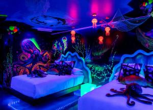 two beds in a room with neon lights at The Cove At Salem in Salem